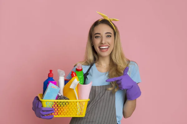 Housewife points finger at basket with cleaning supplies — Stock Fotó