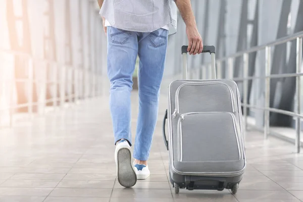 Viaje de fin de semana. Hombre irreconocible caminando con equipaje en el aeropuerto, vista trasera — Foto de Stock