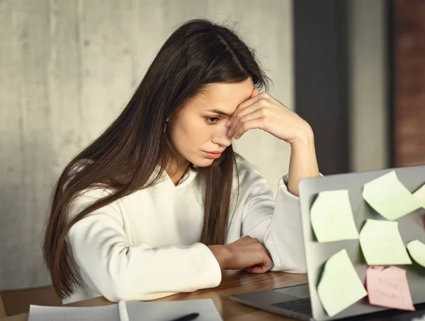 Woman is tired while working and holding head — Stock Fotó