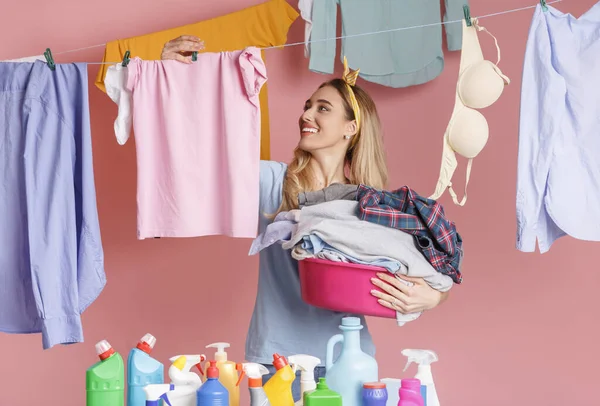 Housewife hangs clean clothes near cleaning supplies — Stok fotoğraf