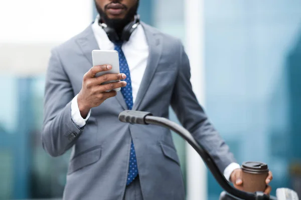 Black businessman texting on phone drinking tea — Zdjęcie stockowe