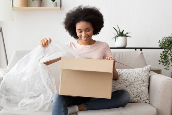 Online shopping from couch. Woman opens purchase — Φωτογραφία Αρχείου