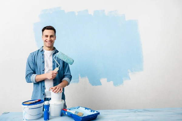 Joven sonriente con herramientas y pintura — Foto de Stock