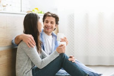 Mutlu eşler kahveyi sever, mutfakta yerde otururlar.