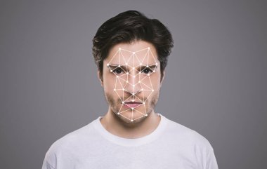 Biyometrik tanımlama. Genç erkek kameraya bakıyor. Yüzünde gri arka planda çokgen ağ var.