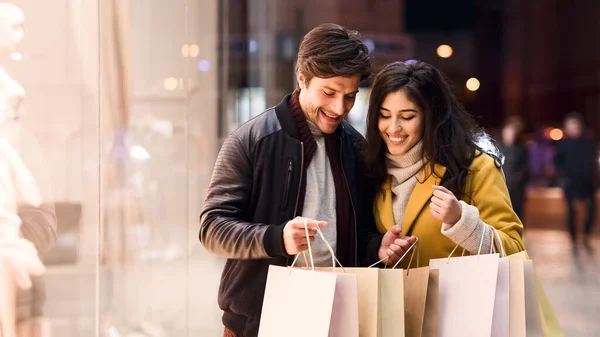 Młoda kochająca się para spacerująca w torbach na zakupy — Zdjęcie stockowe
