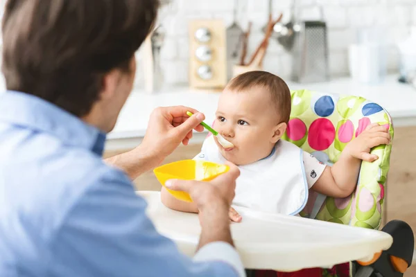 Тоддлер ест здоровую детскую еду на кухне — стоковое фото