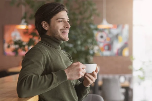 Щасливий хлопець п'є чай або каву в кафе — стокове фото