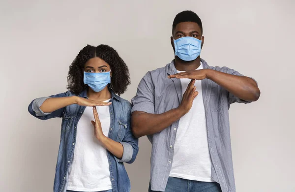 Young Black Couple In Protective Medical Masks Showing Time-Out Gesture