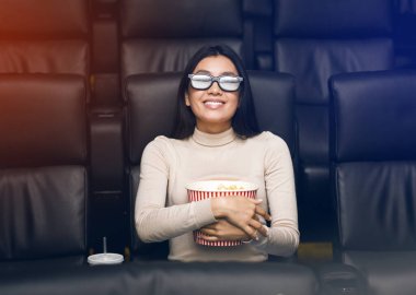 3D gözlüklü Asyalı kız sinemada ilginç bir film izliyor.