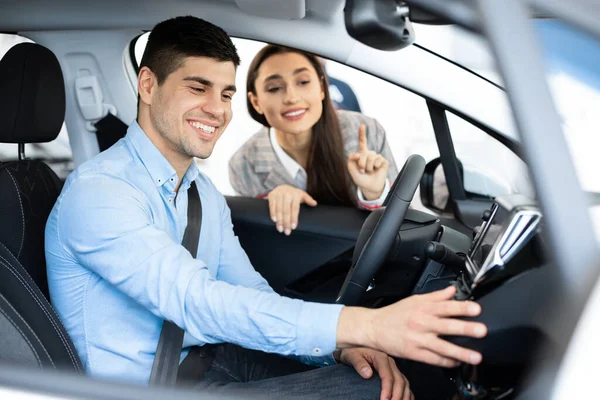 Ehefrau hilft Ehemann bei der Wahl eines neuen Autos im Autohaus — Stockfoto