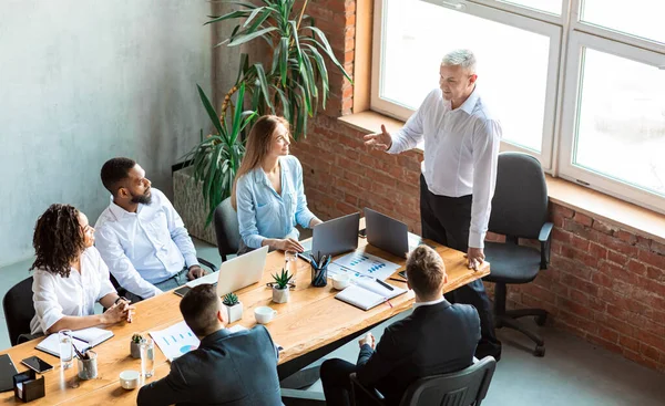 Empregador dando discurso em reunião com funcionários sentados no escritório — Fotografia de Stock