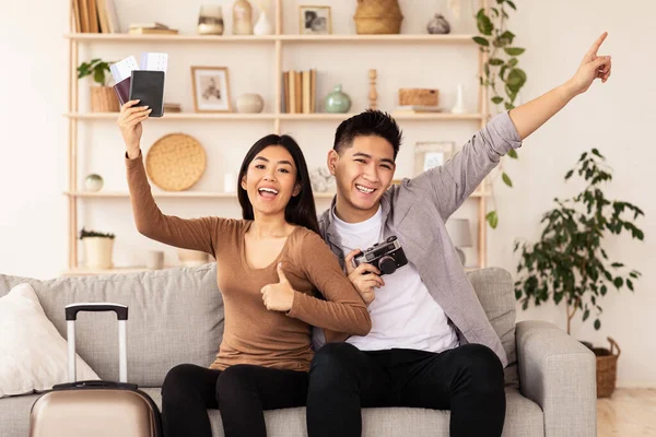 Asian Spouses Holding Flight Tickets Celebrating Vacation Sitting At Home