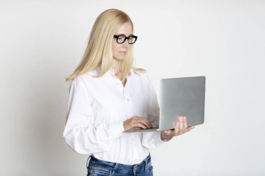 Stüdyoda dizüstü bilgisayar kullanan kendine güvenen iş kadını