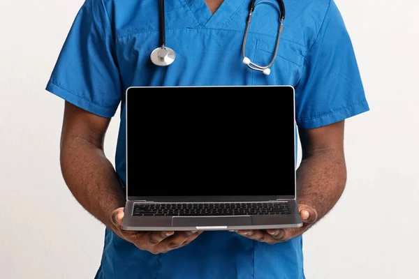 Pusty ekran laptopa w afrykańskich rękach amerykańskiego lekarza — Zdjęcie stockowe