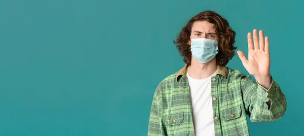 Millennial man in masker maken Stop gebaar, protesteren tegen epidemie op kleur achtergrond, kopiëren ruimte. Panorama — Stockfoto