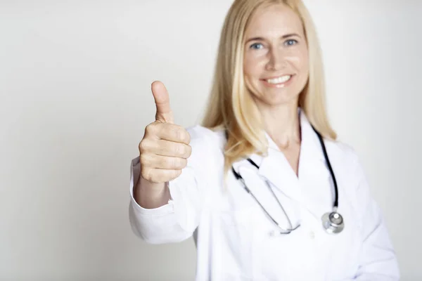 Feliz maduro mulher médico no uniforme com polegar para cima — Fotografia de Stock