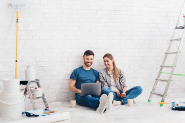 Genç, gülümseyen bir çift yeni dairelerini yeniliyor ve yeniliyorlar.