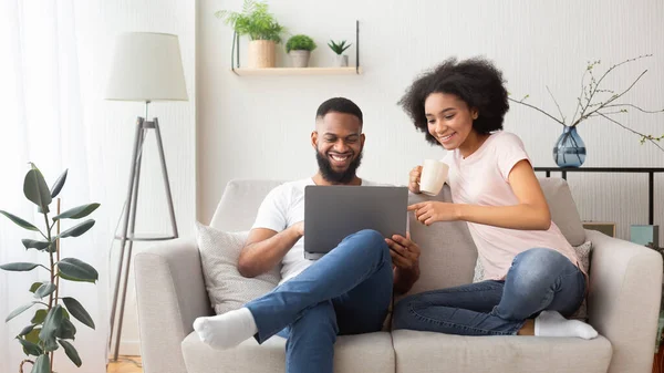 Afrikaans amerikaans paar op bank met laptop — Stockfoto
