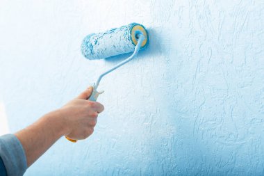 Tekerlekli renkli erkek el mavi renkli desen duvarı