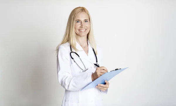 Frau mittleren Alters hält Ordner über graue Wand — Stockfoto