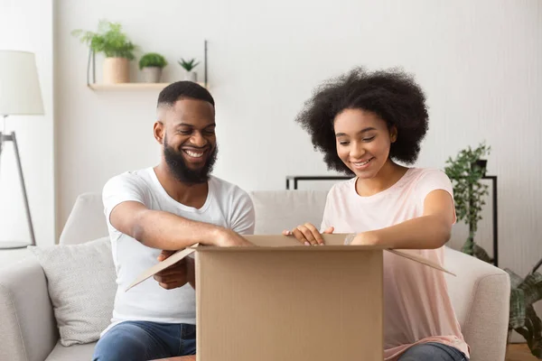 Lächelnd öffnen Mann und Frau eine Schachtel aus Online-Shop — Stockfoto