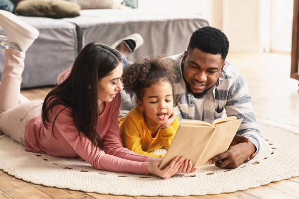 International family reading book on the floor — Stock Photo, Image