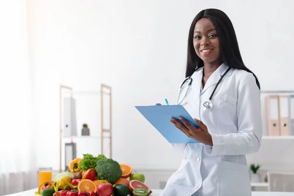 Pozitif siyah kadın dietolog elinde sağlık raporu tutuyor. — Stok fotoğraf
