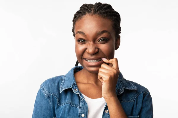 Afro-américaine fille dans orthodontie accolades grimacing, studio shot — Photo