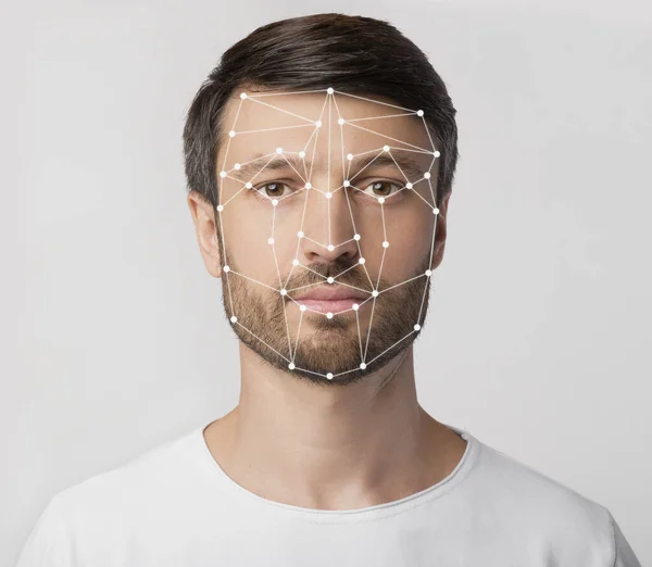 Personal safety. Caucasian man with face scanning grid on light background
