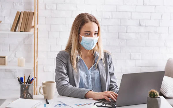 Remote work during epidemic. Woman works in protective mask — Stock Photo, Image