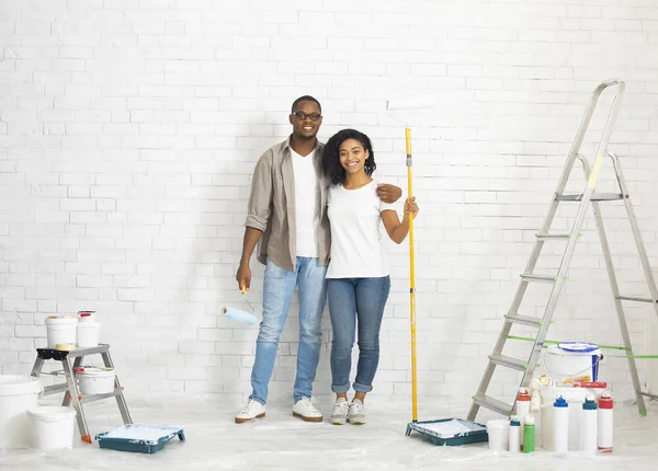 Couple with repair tools and paint on white brick wall background — Stock Photo, Image