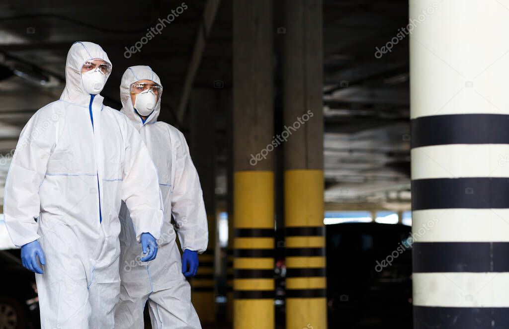 Men in virus protective suits patrol the city while quarantine