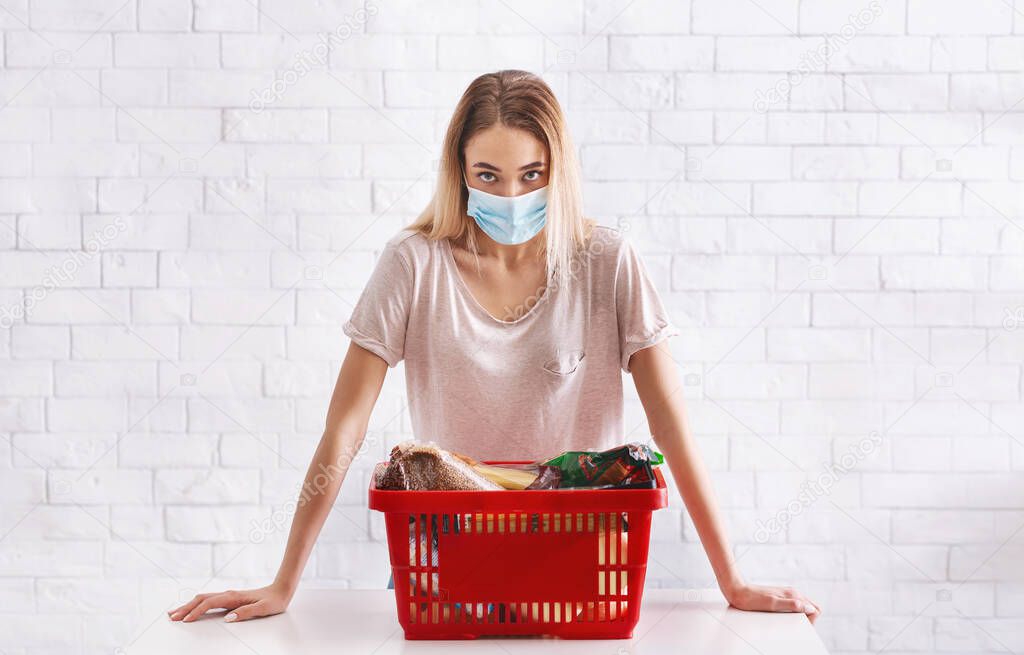 Quarantine at epidemic. Girl in protective mask with basket of products