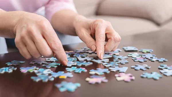 Senior woman playing jigsaw puzzle at home, empty space — Stock fotografie