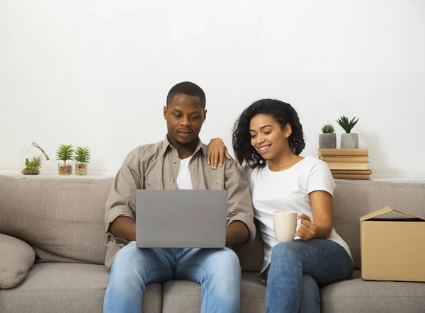 Homem e mulher olhando para laptop e sentado no sofá — Fotografia de Stock