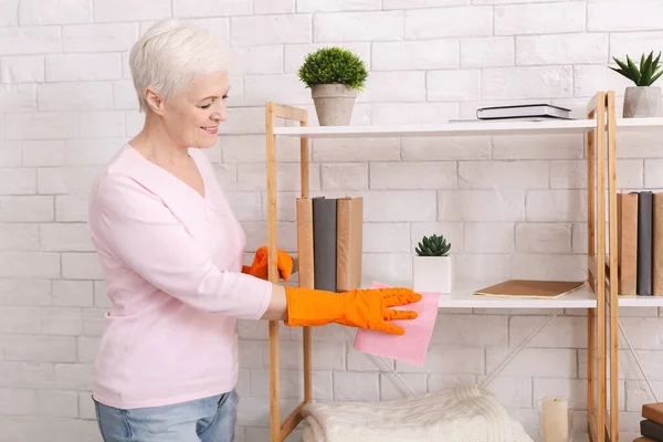 Senior vrouw wast haar meubels tijdens quarantaine thuis — Stockfoto