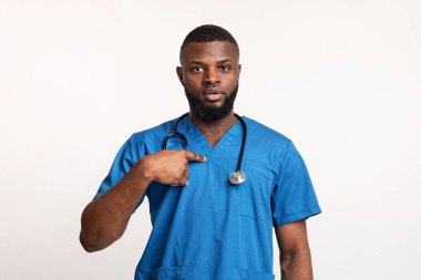 Şaşırmış Afrikalı erkek doktor kendini işaret ediyor.