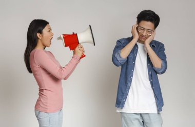 Kızgın Asyalı kız megafonla erkek arkadaşına bağırıyor.