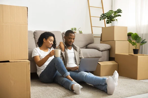 African american couple sitting on the floor looking at laptop — Stock Photo, Image