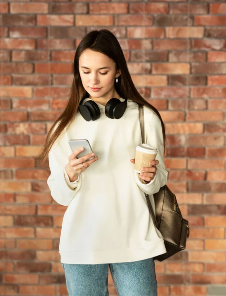 Freelancer com xícara de café digitando no smartphone — Fotografia de Stock