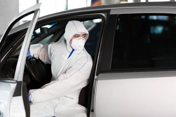 Hombre en traje de protección contra el virus saliendo de su coche — Foto de Stock