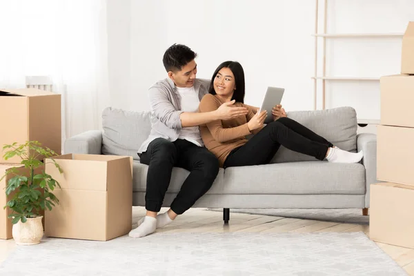 Casal asiático usando tablet digital em novo apartamento — Fotografia de Stock