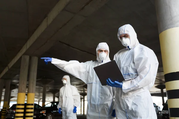 코로나 바이러스에 대한 연구를 하고 있는 특별 한 바이러스 보호 복을 입고 있는 남자들 — 스톡 사진