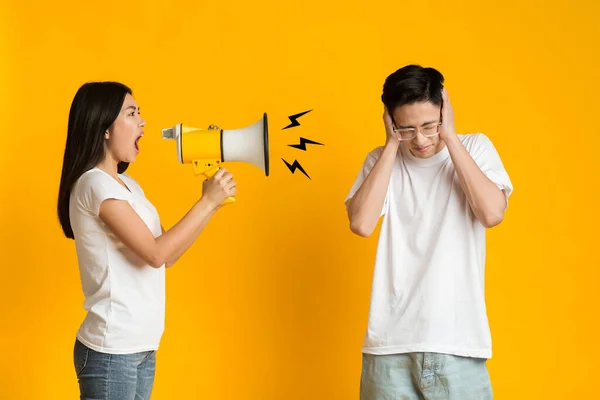 Asiática menina zangada gritando através de megafone com seu namorado — Fotografia de Stock