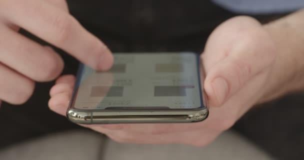 Hombre buscando información en la pantalla de su teléfono inteligente — Vídeos de Stock