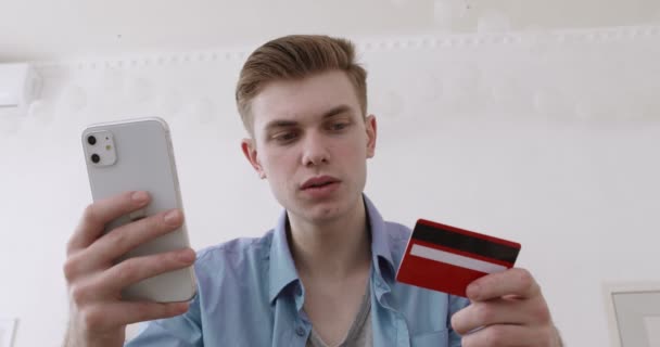 Jongeman faalt proberen om online te betalen met mobiele telefoon en creditcard — Stockvideo