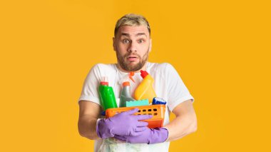 Elinde sepet dolusu temizlik malzemesi olan komik bir adam.