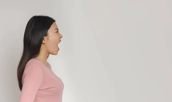 Vista lateral da menina asiática gritando em direção ao espaço de cópia — Fotografia de Stock