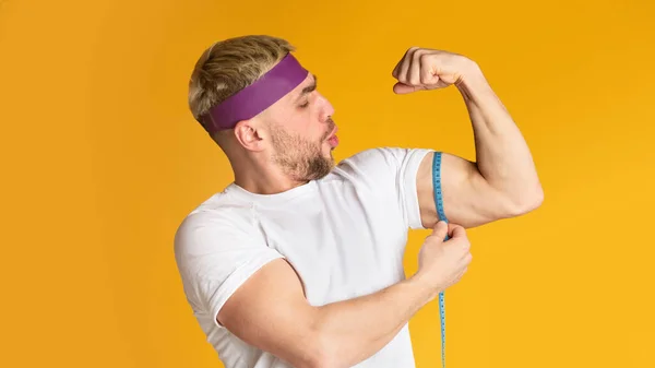 Hombre orgulloso de sí mismo y mide bíceps — Foto de Stock